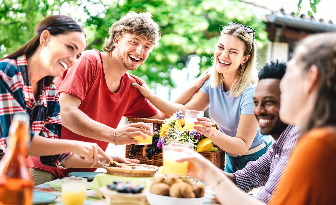 friends eating outdoors toasting drinks