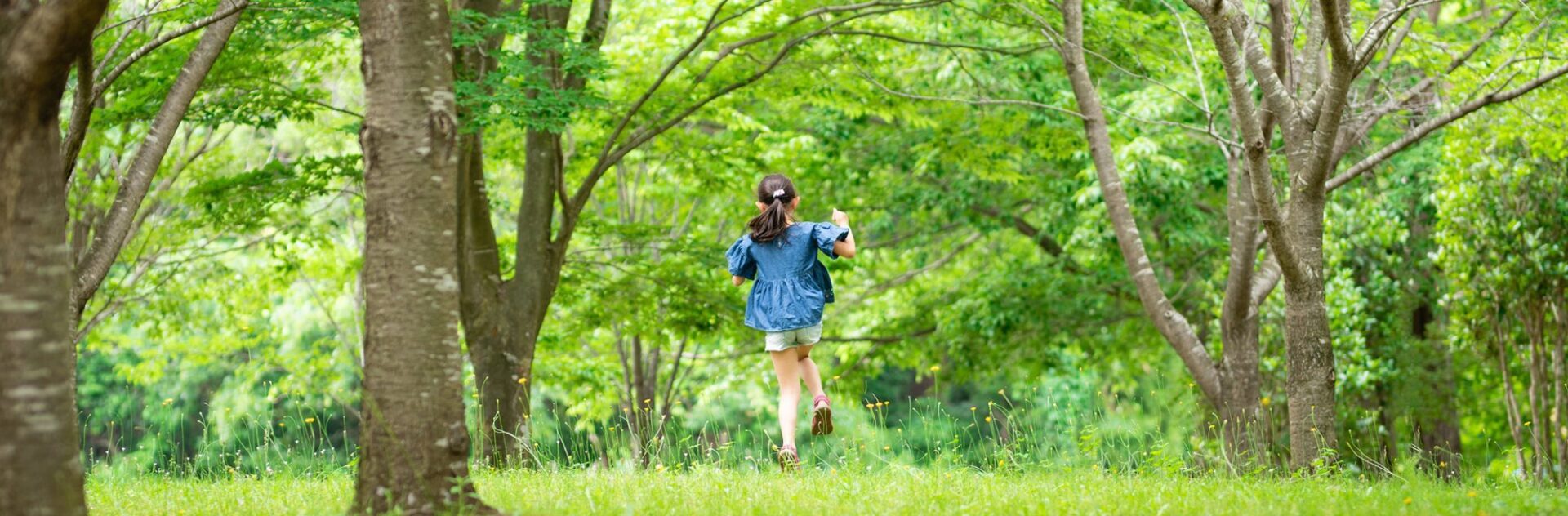 girl running through a tree grove